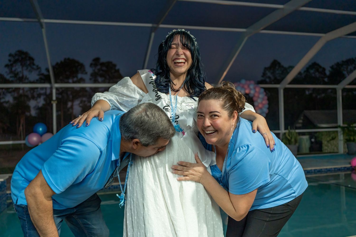 Emotional gender reveal moment with expecting parents and family celebrating by the pool during a South Florida gender reveal party.
