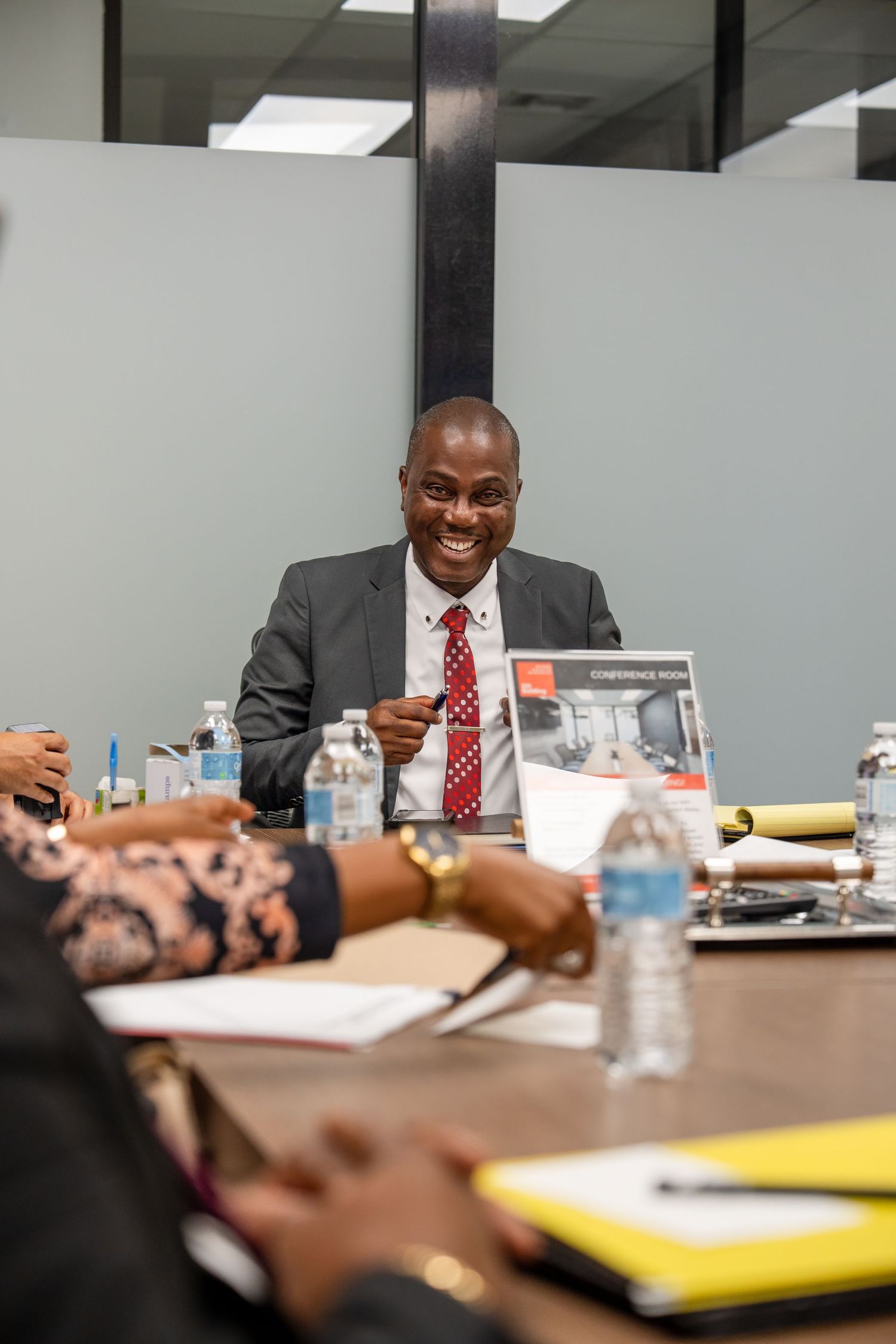 Corporate lifestyle photo of a professional leading a meeting at a conference table in a modern office setting.