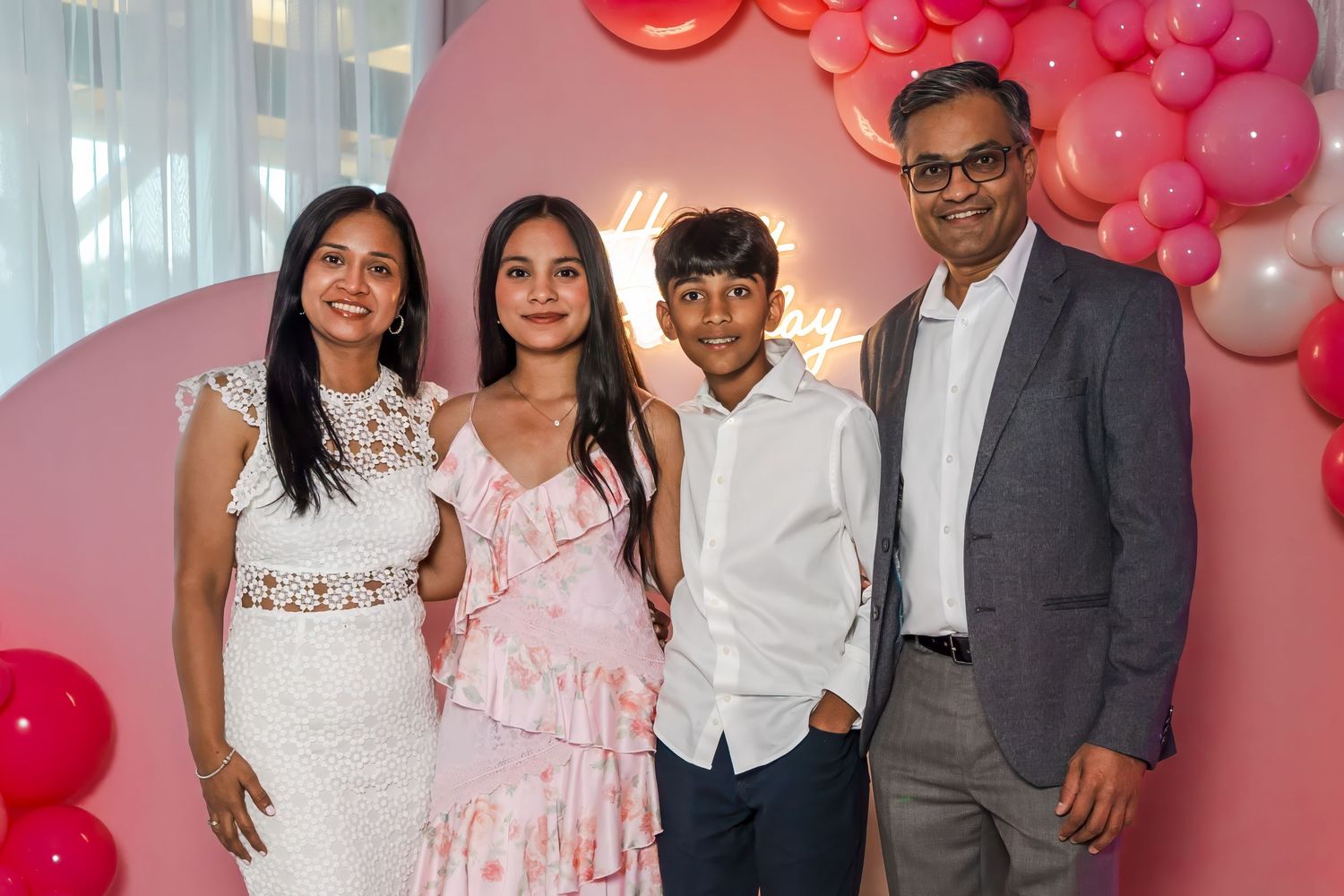 Full family portrait at a South Florida Sweet 16 celebration with elegant pink decor.