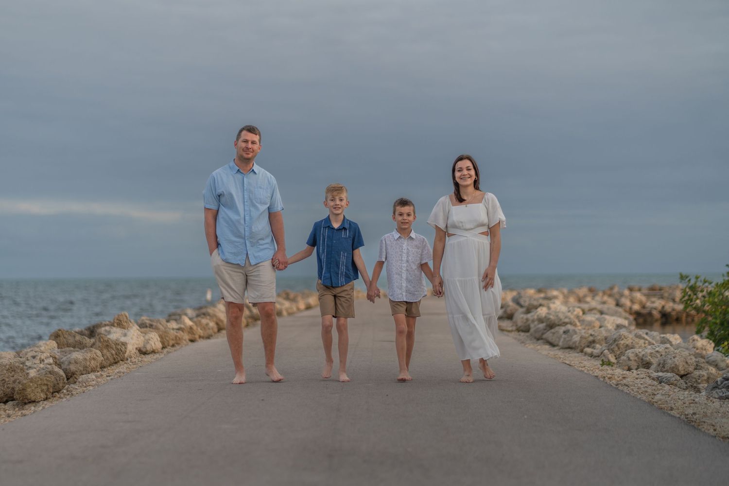 Family posing by the boat ramp at Harry Harris Park, Key Largo, FL, with clear blue waters in the background.