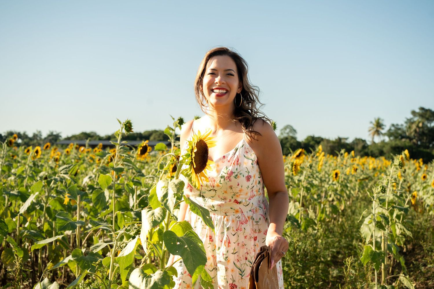 Portrait of woman walking through sunflowers during Berry Farms birthday event.