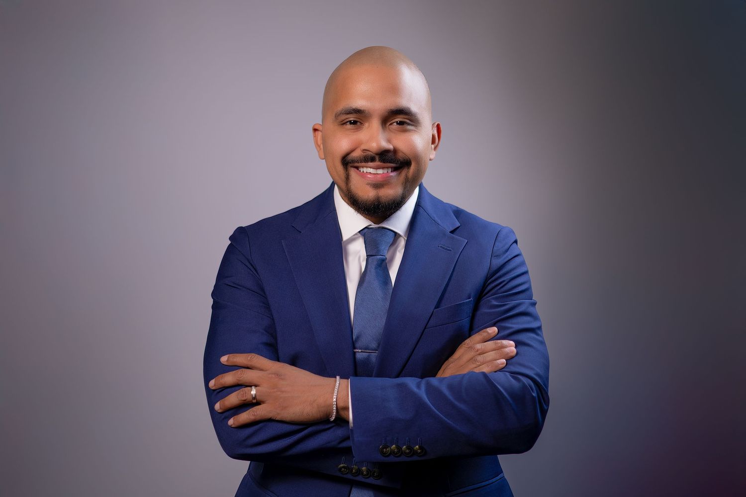 Man in blue suit with arms crossed during studio headshot session
