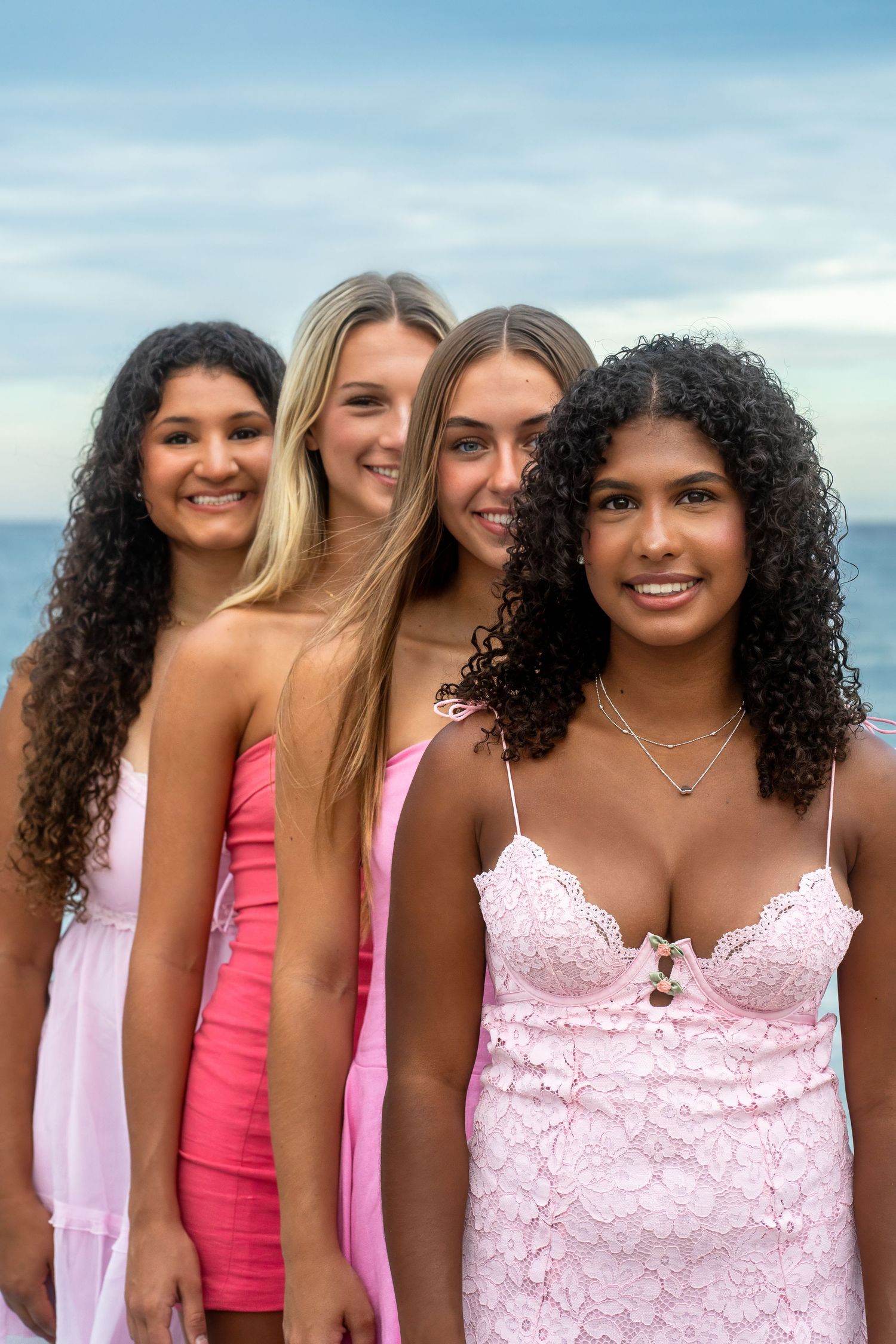 Cheer squad portrait featuring confident expressions and soft coastal light during a South Florida beach session.