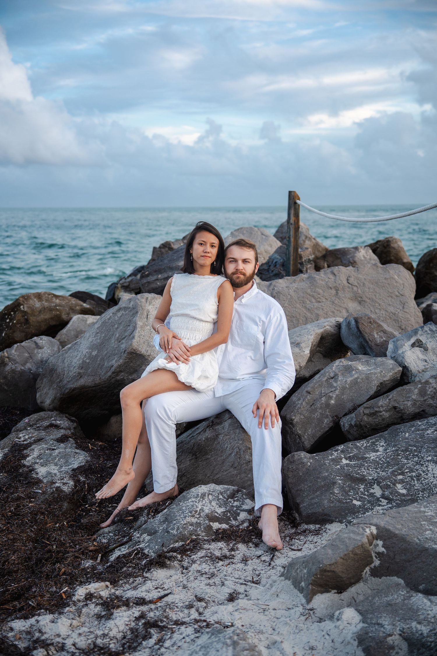 Couple embracing on the shoreline during a South Florida beach engagement session.