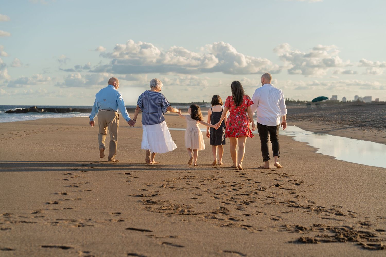 Sunset family beach stroll in Delray Beach, FL – holding hands and walking together along the shoreline.