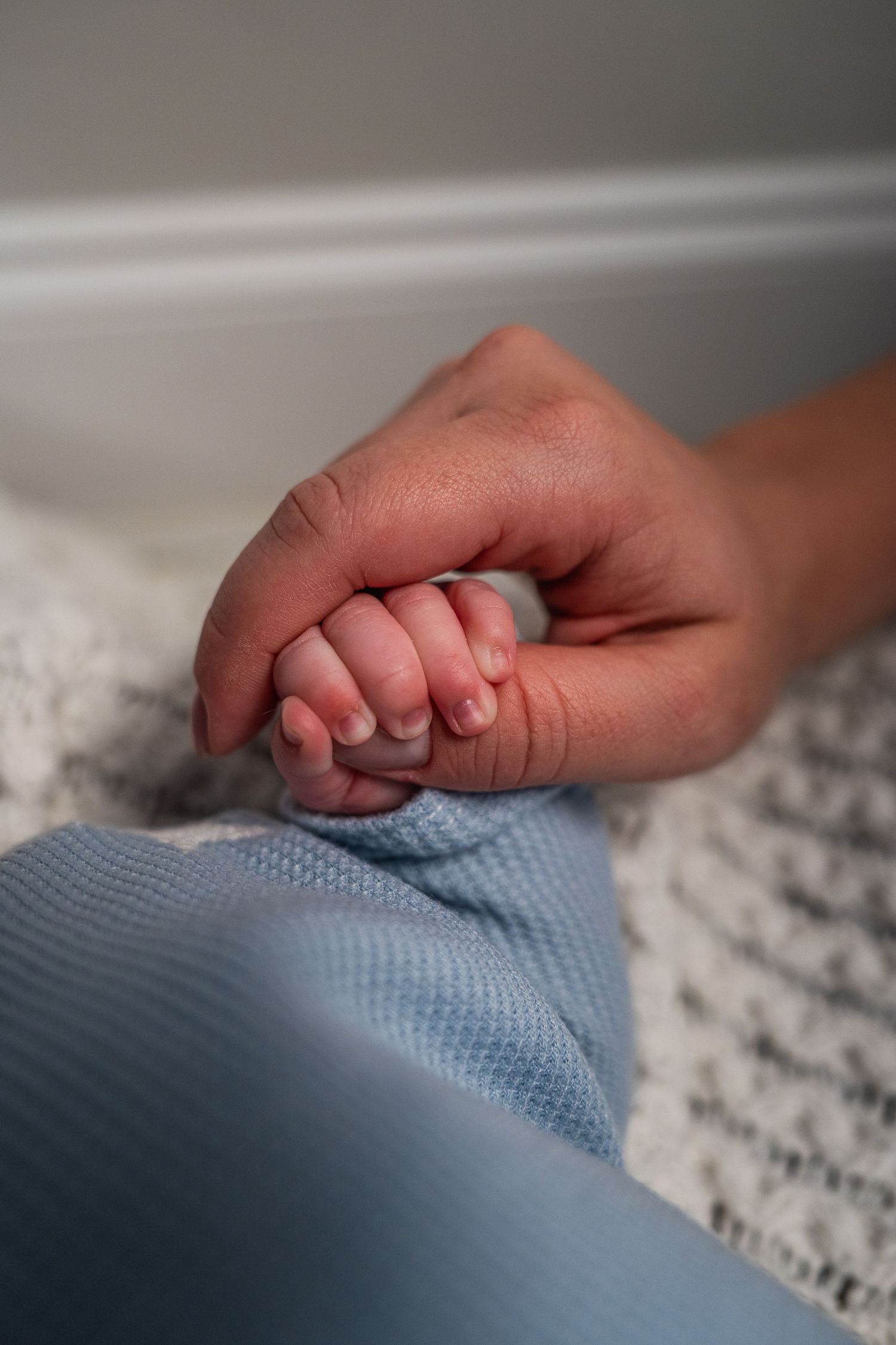Newborn detail photo of baby holding parent’s finger in Fort Lauderdale