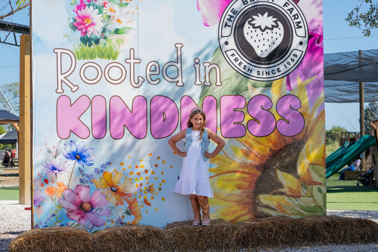 Birthday girl in front of ‘Rooted in Kindness’ backdrop, from a party at Berry Farms in South Florida.