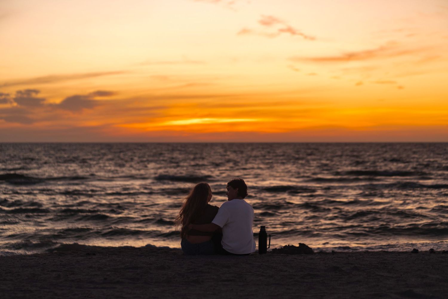 Romantic South Florida beach photo of couple watching sunset on New Year’s Day