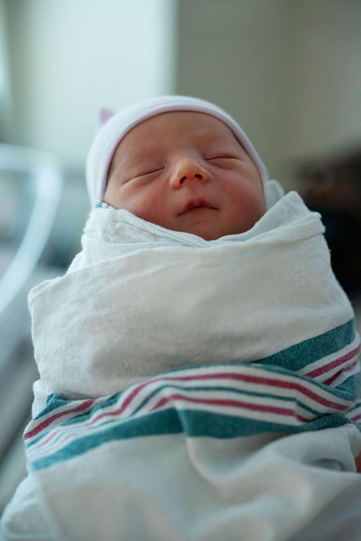 Newborn photography in Miami of baby wrapped in blanket with soft lighting