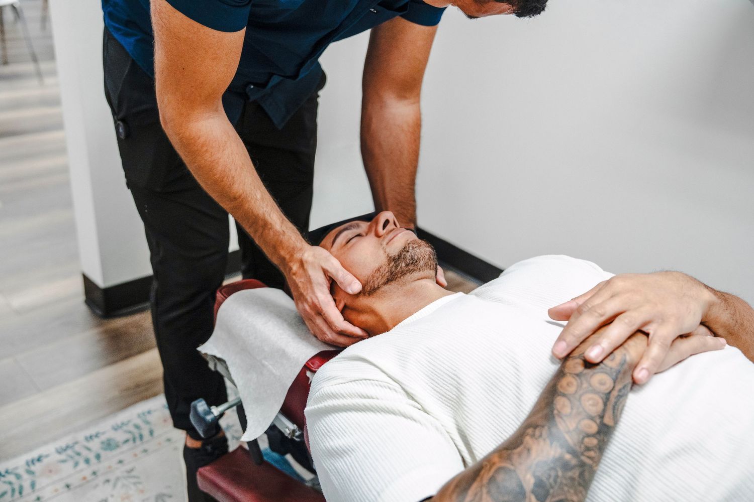 Chiropractor performing neck adjustment during branding session in South Florida clinic