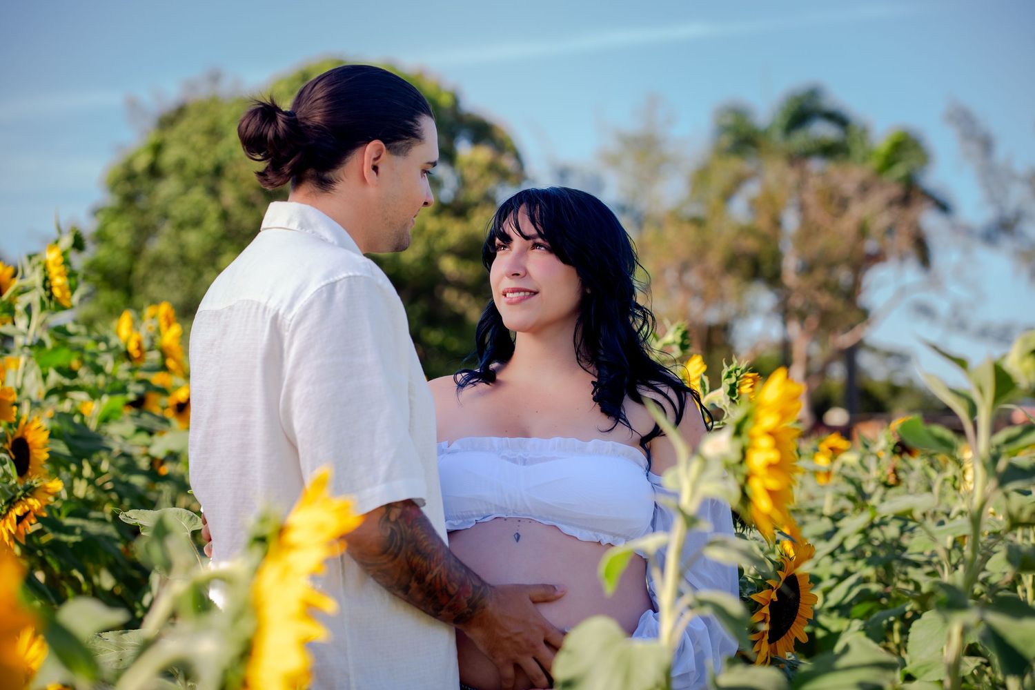 Expecting couple captured in sunflowers during a South Florida maternity session.