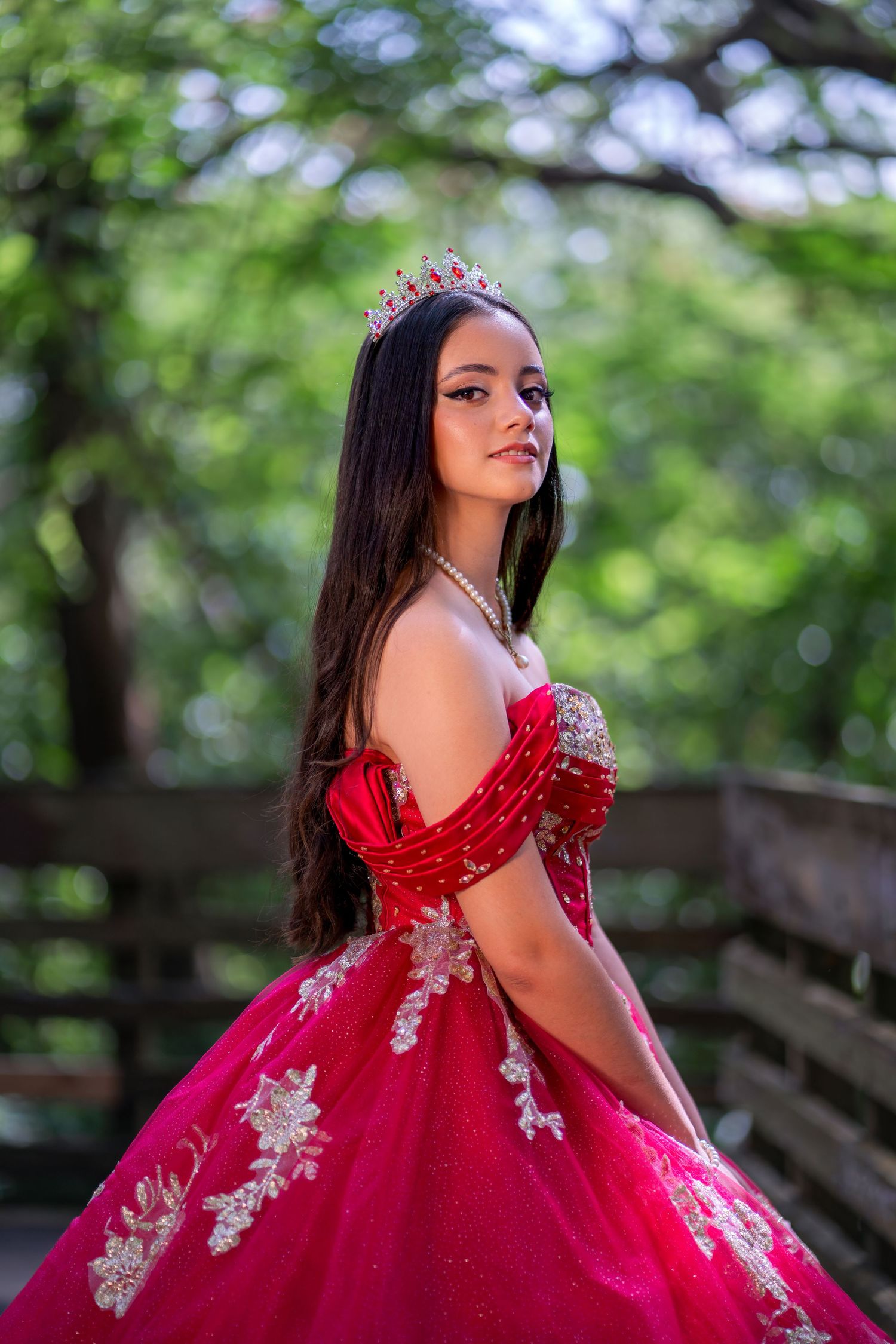 Side profile of a birthday girl in a fitted red dress with tiara at a South Florida park.