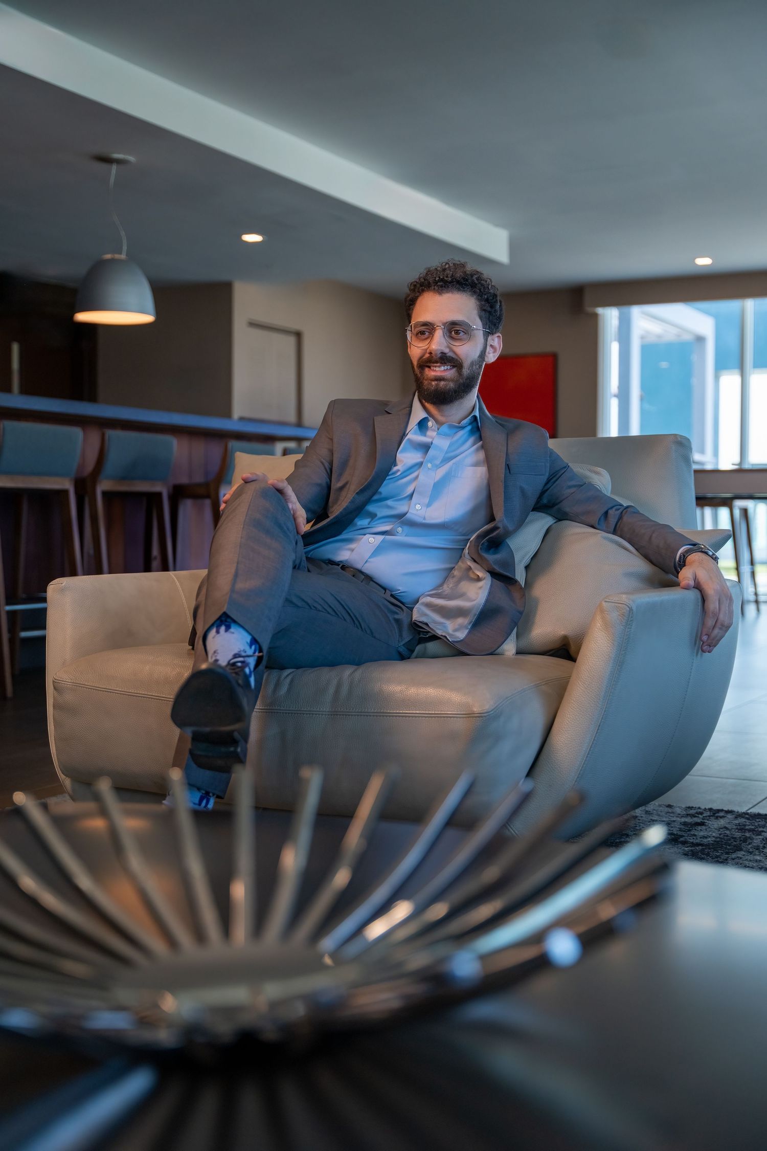 Luxury branding session in Miami, FL – confident entrepreneur relaxing in a modern lounge with city views