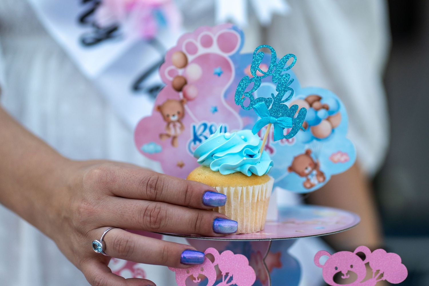 Close-up of a decorated gender reveal cupcake with pink and blue details at a South Florida celebration.