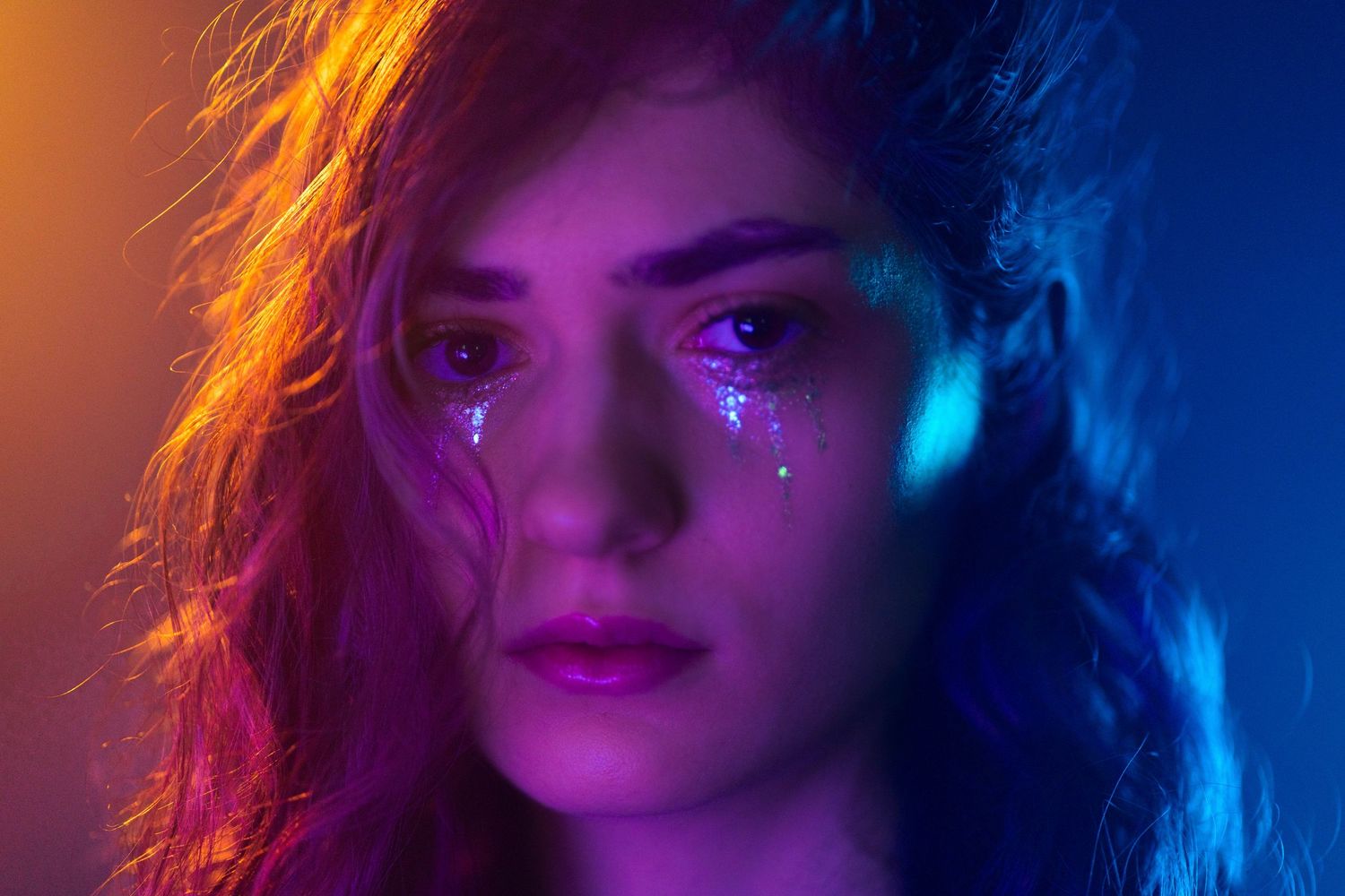 Creative editorial headshot in Boca Raton, FL – glitter tears and neon lighting add a dreamy, surreal effect.