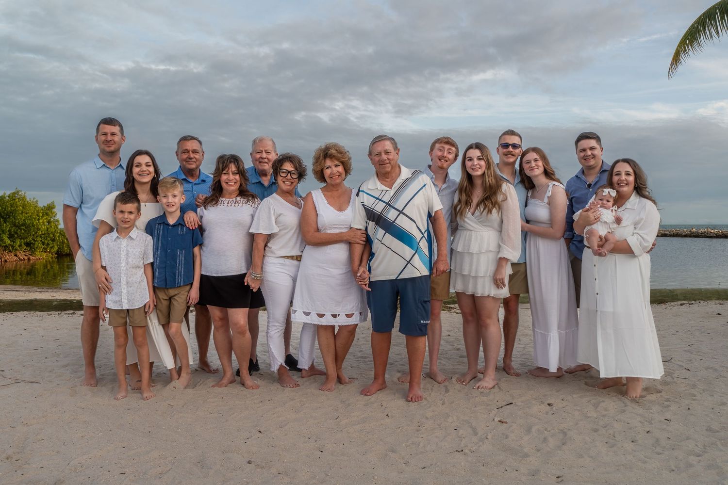 Large family gathering at Harry Harris Park, Monroe County, FL – barefoot on the sand with tropical palm trees and ocean in the background.