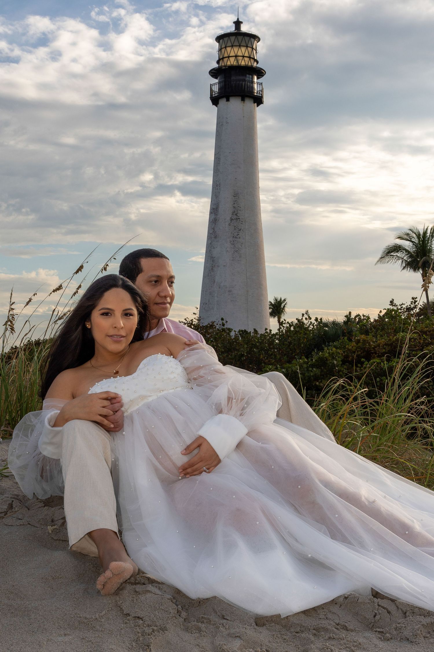 Dreamy beach maternity session at Cape Florida Lighthouse, featuring a glowing mother-to-be and soft ocean waves.