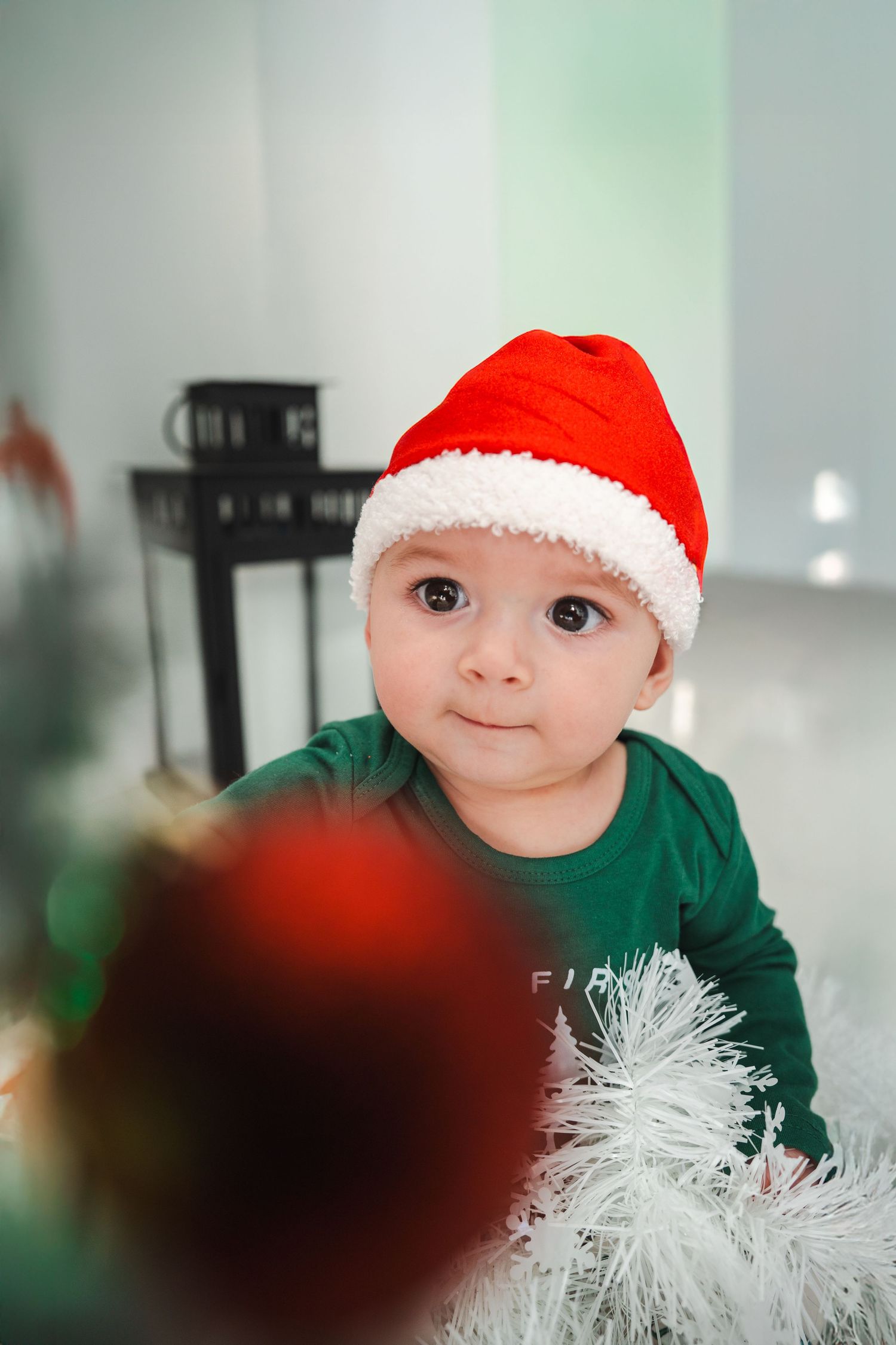 Baby wearing a Santa hat during a cozy indoor Christmas photo session in South Florida.