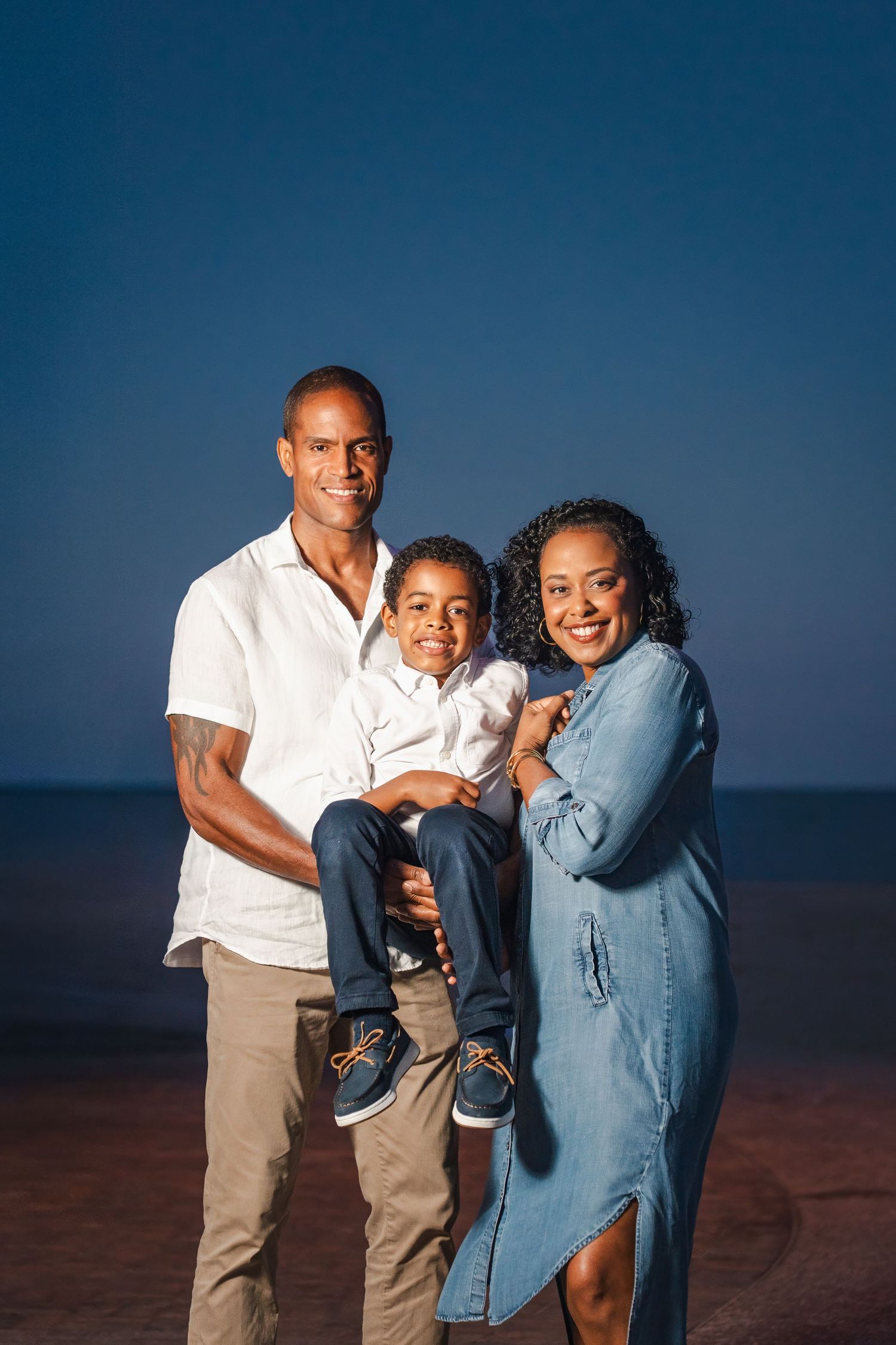 Parents holding their child close during a warm, connected family photo session in South Florida. Miami