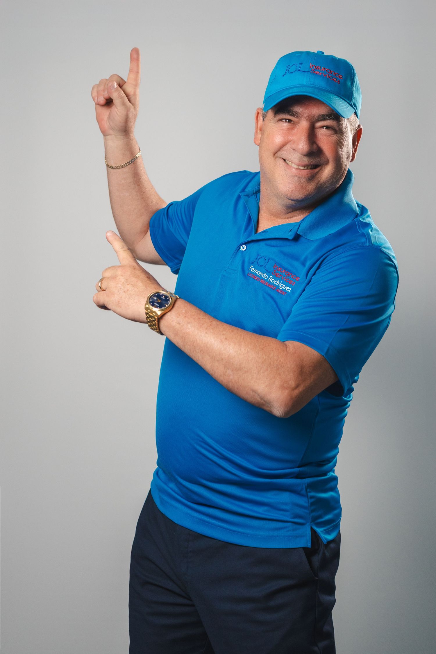 Team member in branded blue polo striking a playful pose in a studio headshot.