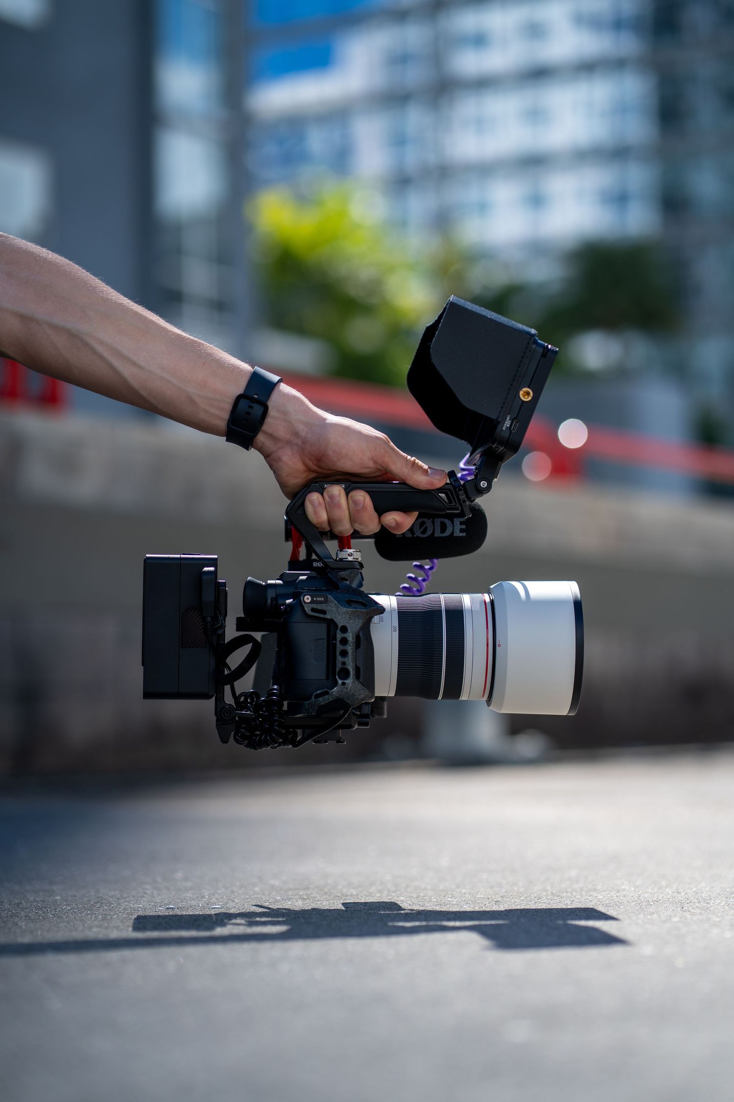 Low-angle shot of video camera with telephoto lens, capturing dynamic branding visuals on location.