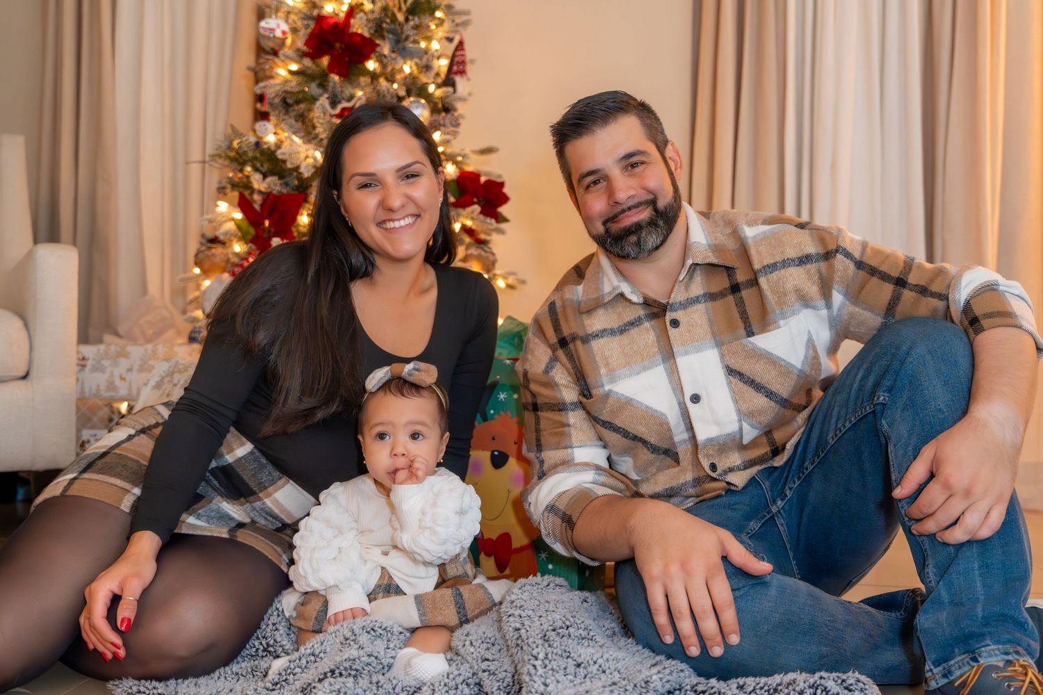 Cozy Christmas family session in Boca Raton, FL – parents and baby celebrating the holiday season by the Christmas tree.