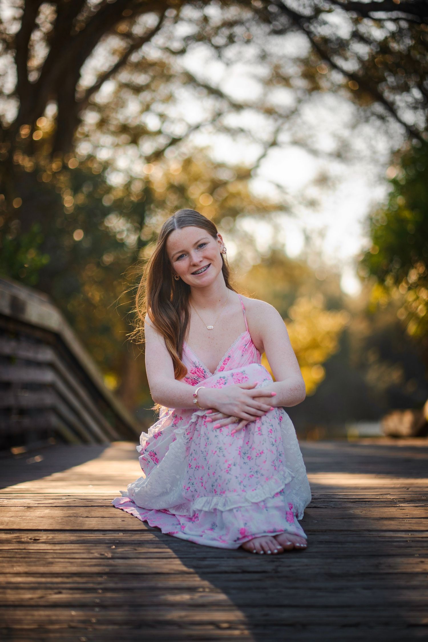 Senior photos in South Florida by photographer, golden hour portrait on wooden bridge with warm natural