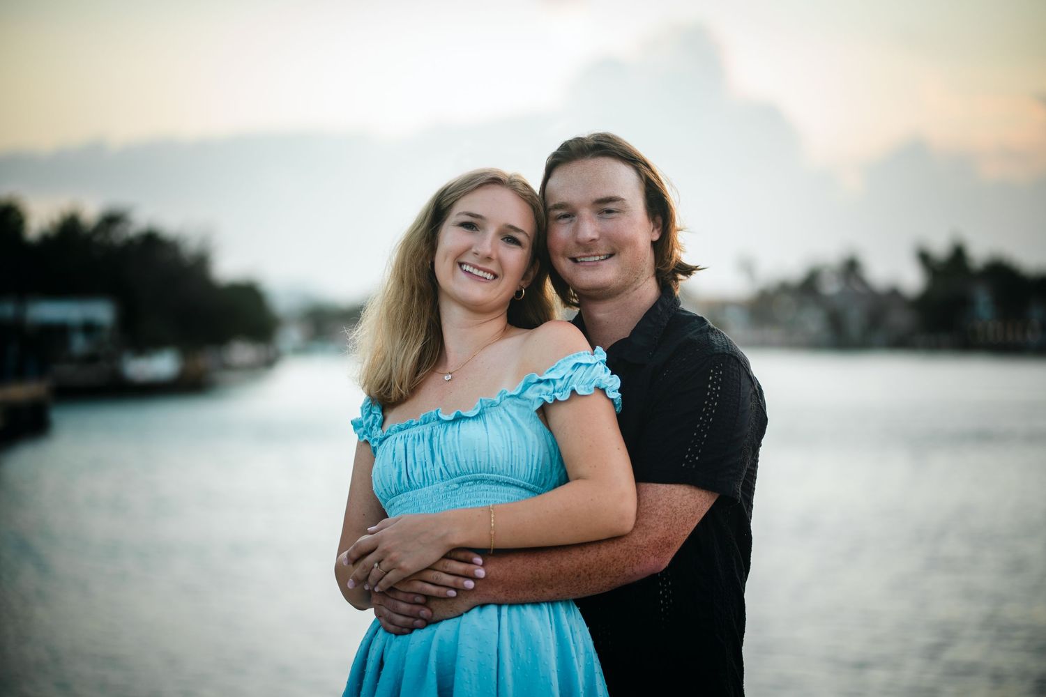 South Florida engagement photography of couple embracing by the water at sunset at Red Reef Park