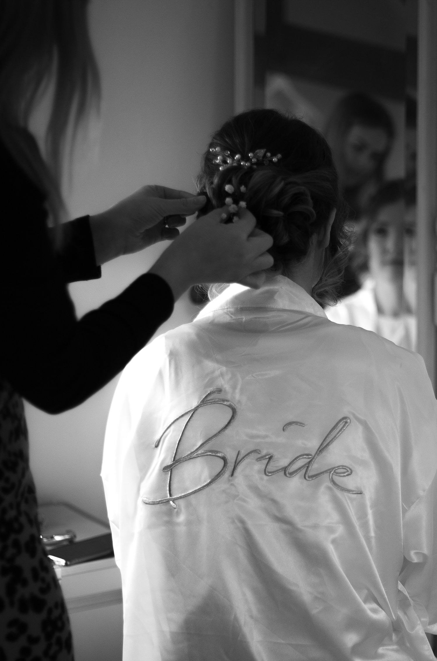 A series of black and white photos showing someone in a white robe with 'Bride' text getting ready for a wedding.