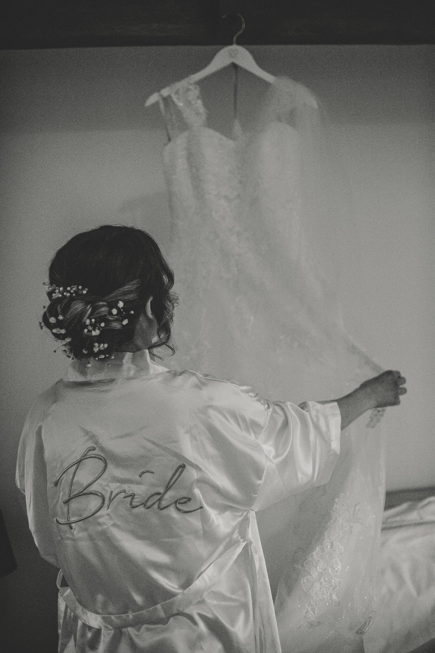 Black and white photo series showing the back of a silk bridal robe with 'Bride' embroidered text during wedding preparations.