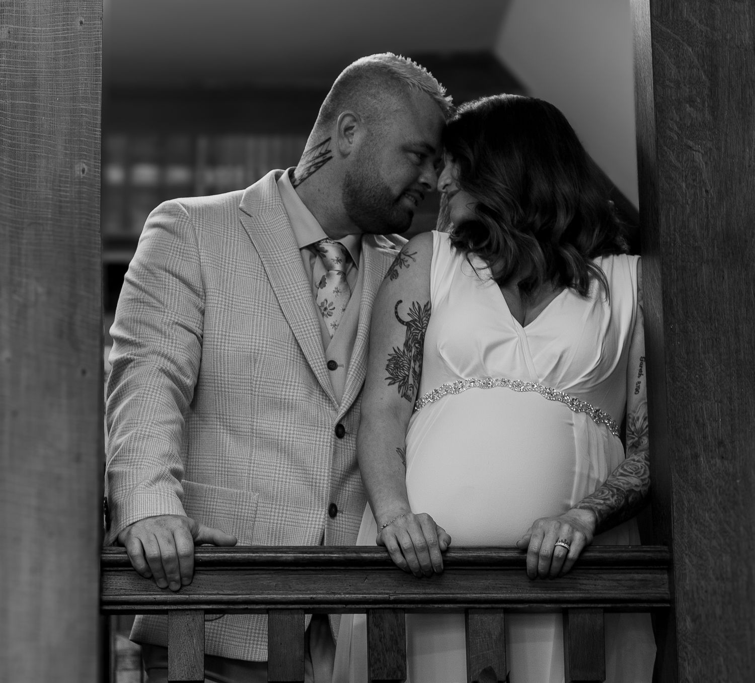A black and white wedding photo series showing intimate moments between a couple in formal attire.