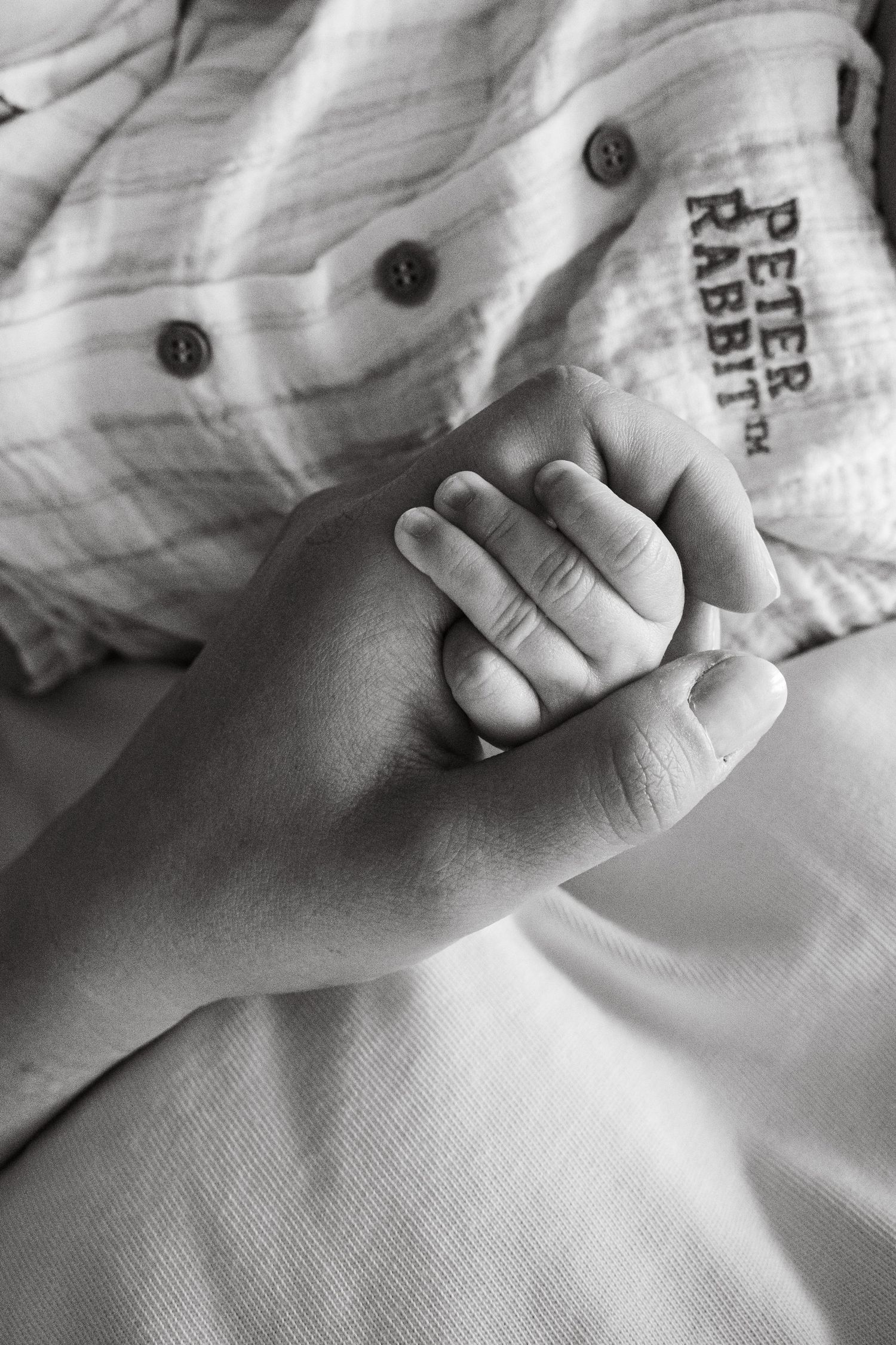 Black and white family photograph of mother and baby having moment of connection during an at home session in Lincoln, UK