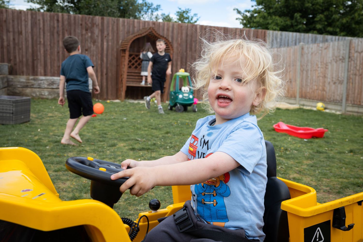 Image of child in their back garden in Lincoln, Lincolnshire. Shows boy in real moment and captured naturally in home setting.