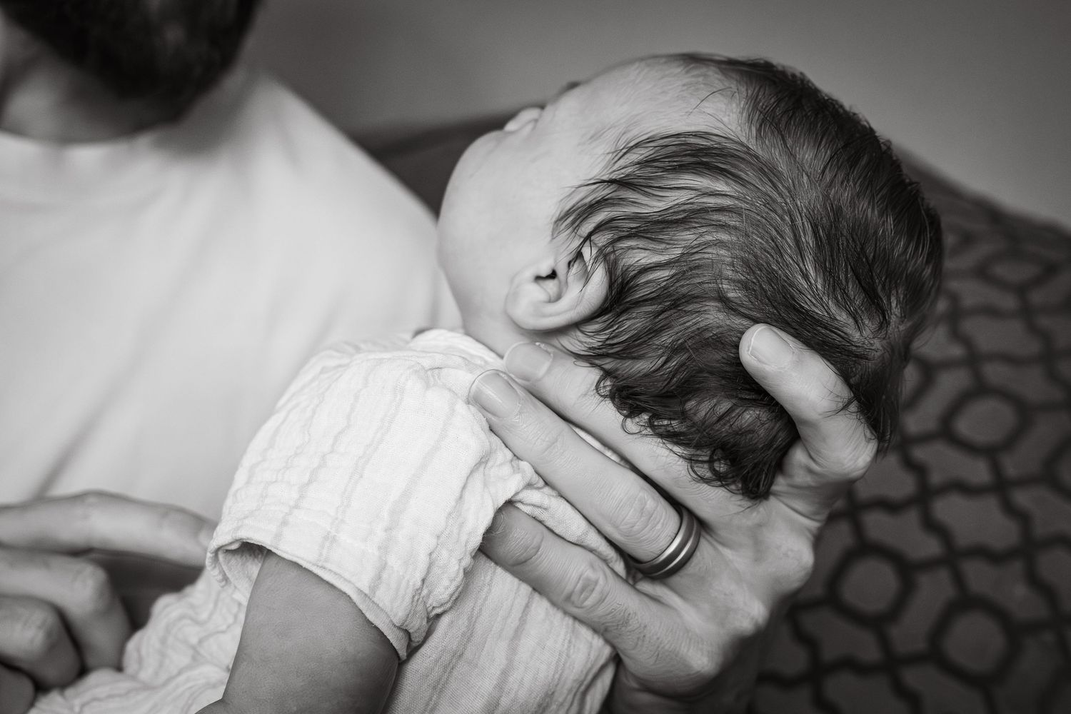 Black and white family photograph of father and baby having moment of connection during an at home session in Lincoln, UK