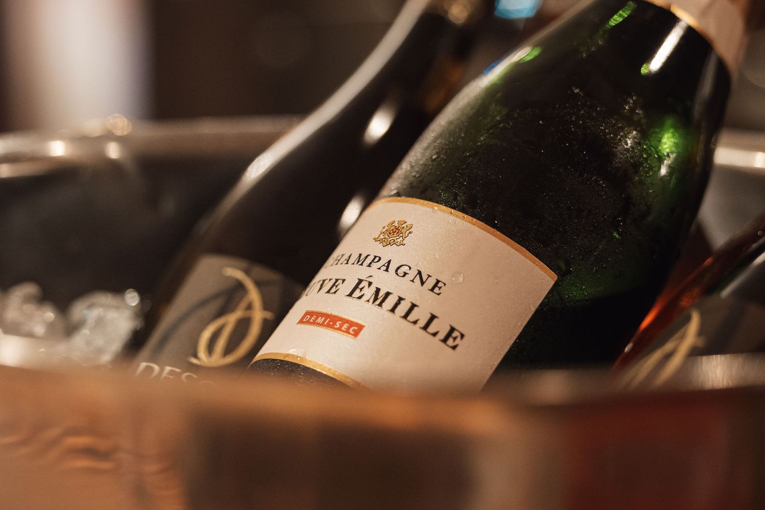 Bottle of Veuve Emille Champagne chilling in an ice bucket at an elegant event.