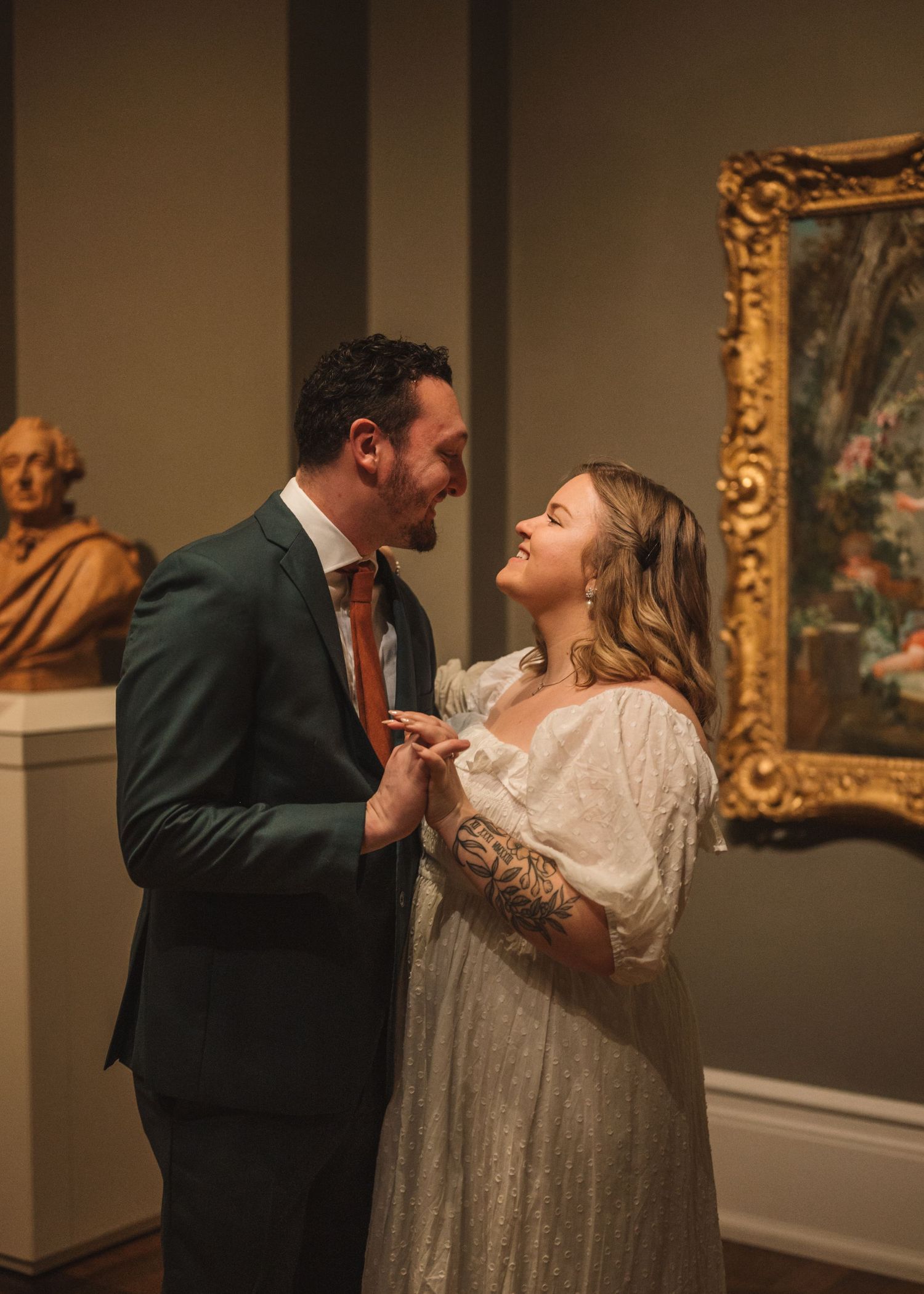 A couple dances elegantly in an art museum gallery surrounded by ornate framed paintings.