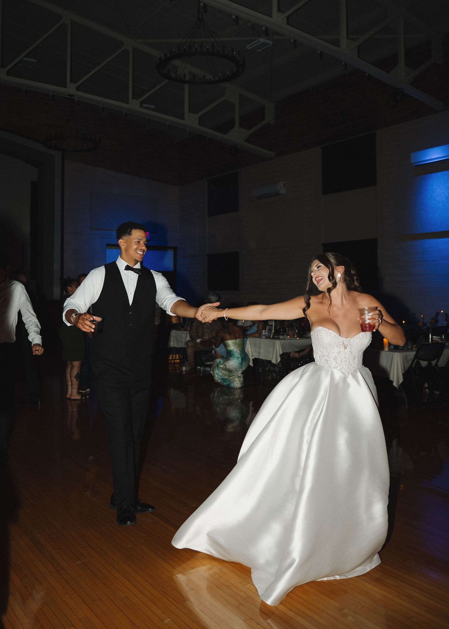 A series of dance photos showing a couple performing a romantic twirl on a wooden dance floor at a wedding reception.