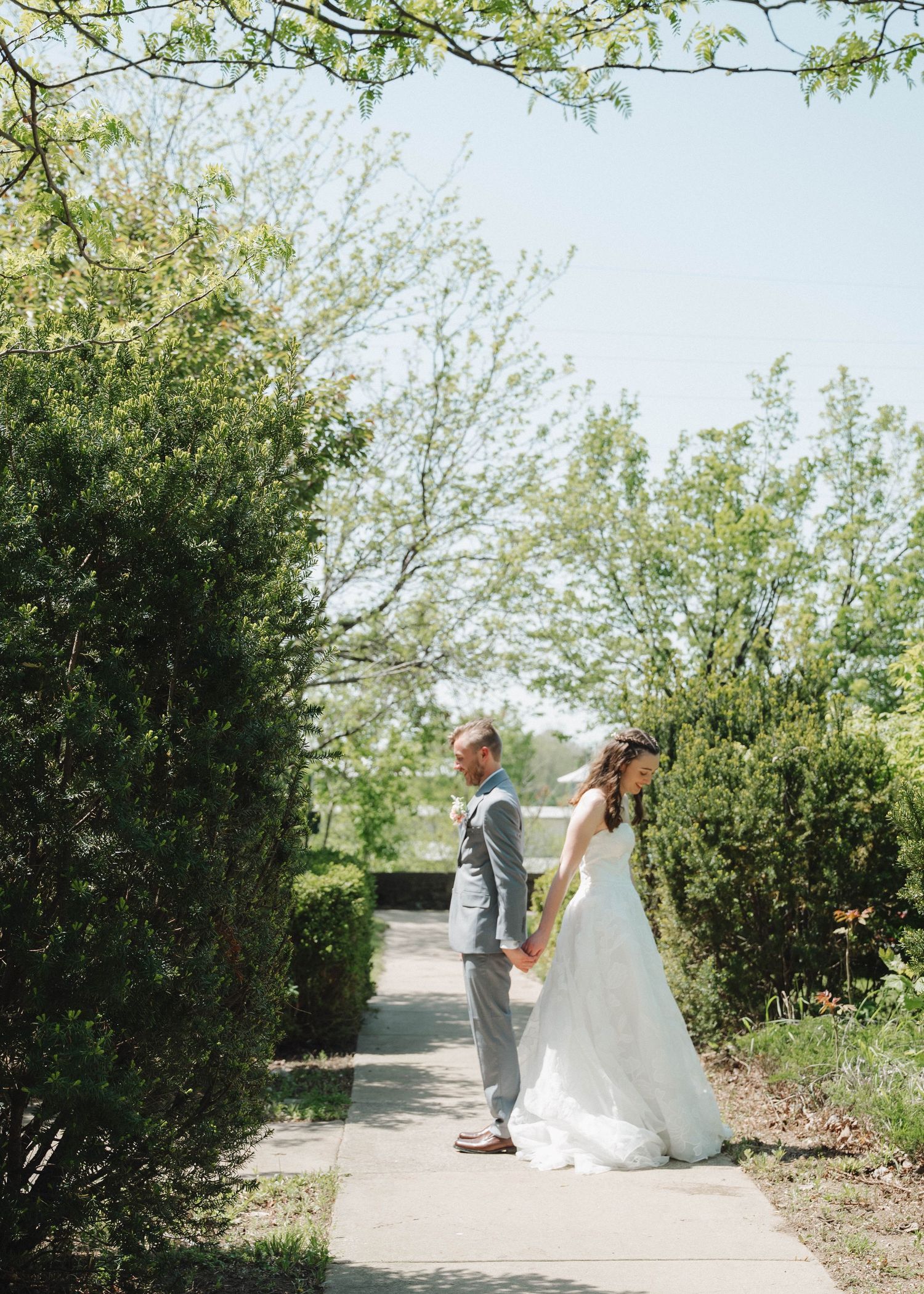 A sequence of wedding photos showing a couple walking along a garden path surrounded by lush greenery.