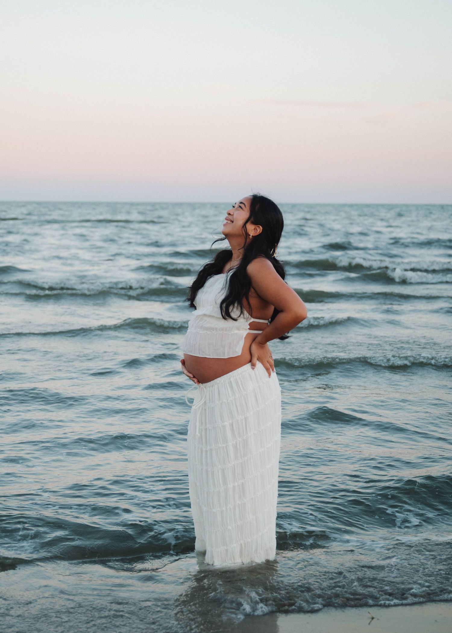 A series of photos showing someone in a white dress joyfully playing in ocean waves at sunset.