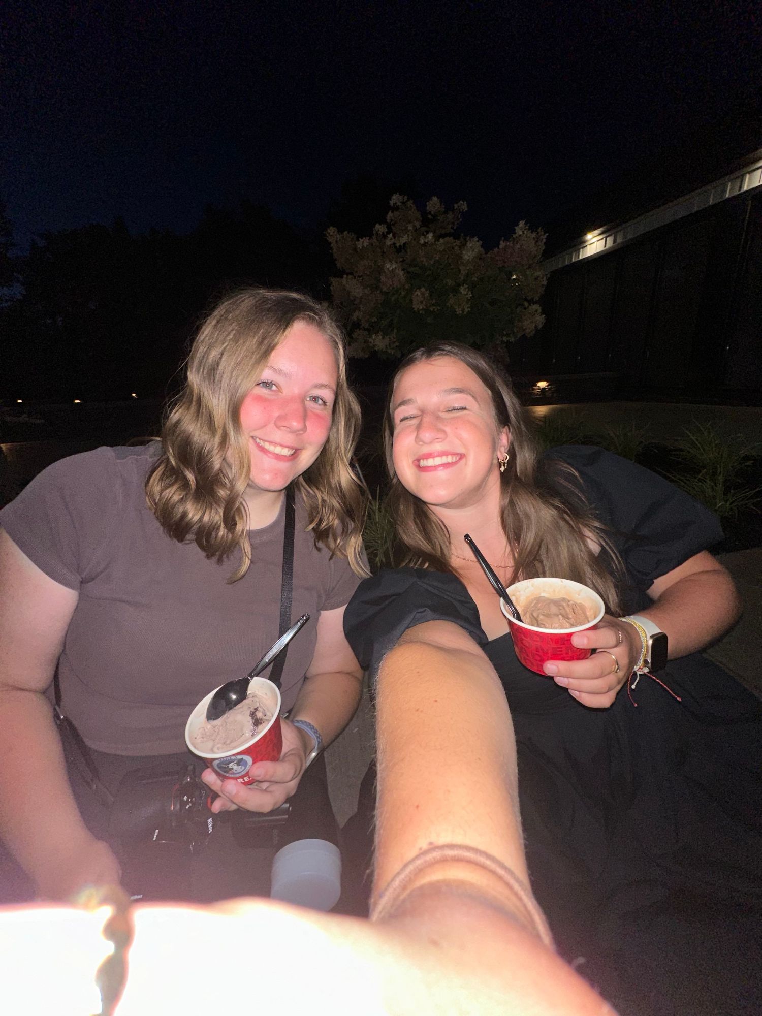 Friends enjoying drinks together during nighttime outdoor gathering.