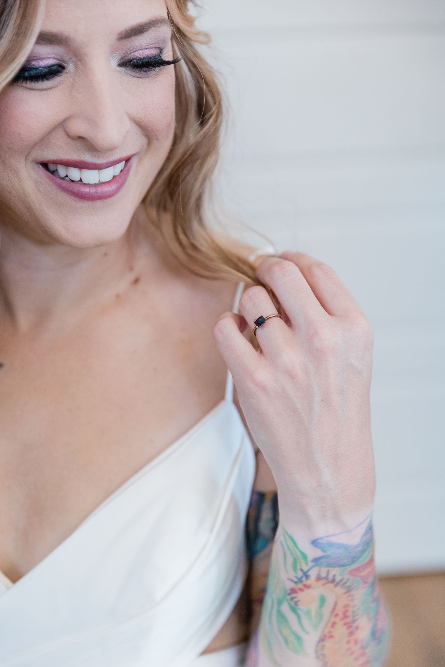Close-up of the engagement ring resting on the bride's dress at her shoulder.