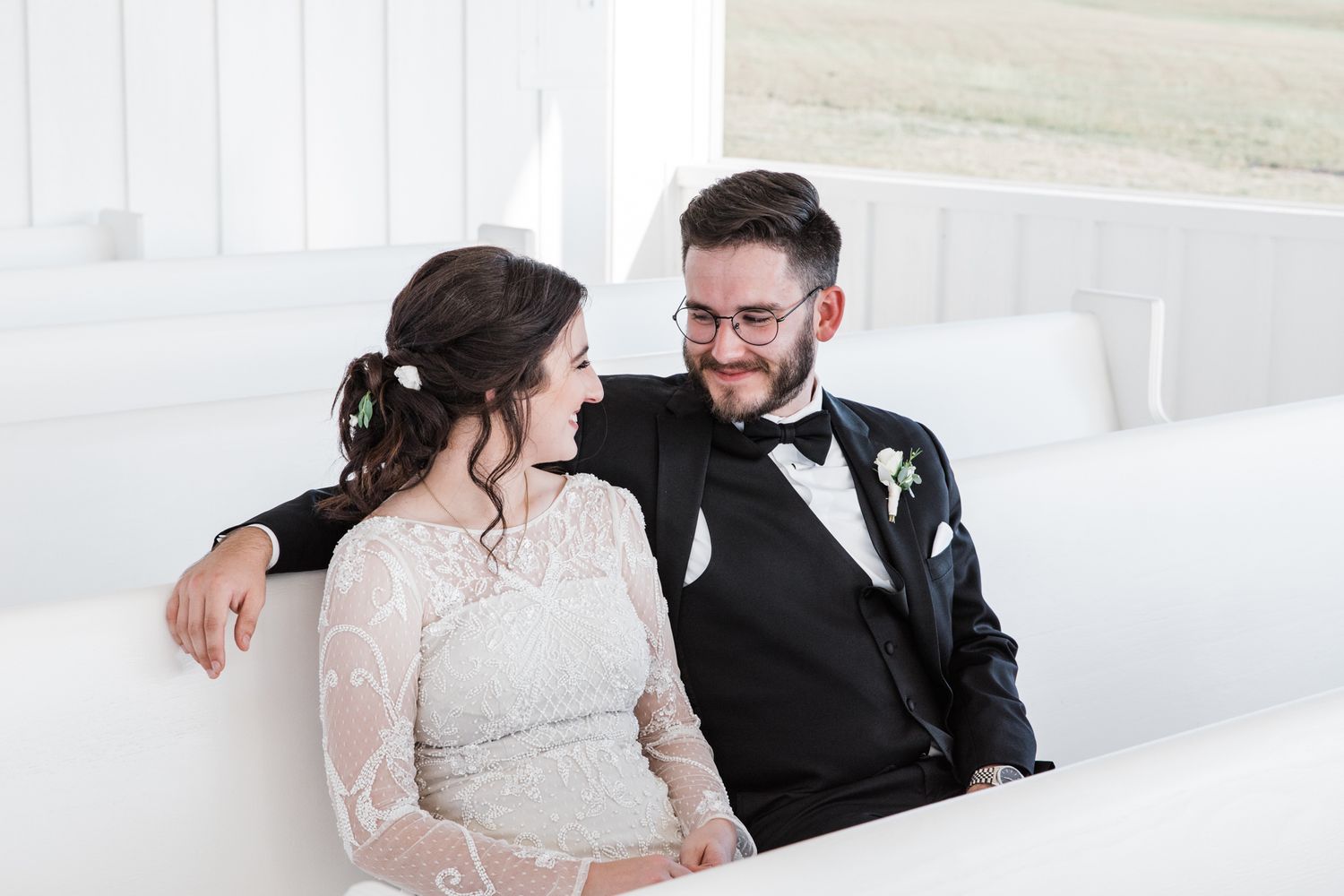 Bride and Groom sitting down in the pews at the chapel site at The Grand Ivory.