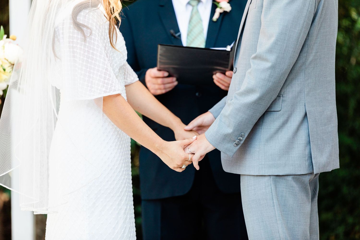 hand holding at the alter during the ceremony for the bride and groom