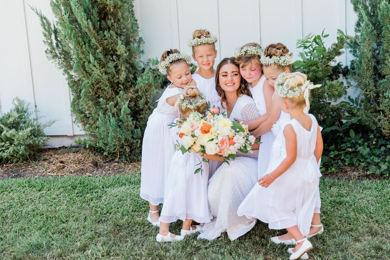 Bride taking a moment with her flower girls during the family formal photos in McKinney Texas.