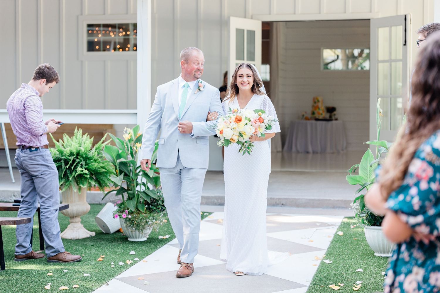 Dad walking his daughter down the aisle for an outside ceremony at The RoseMary Barn in McKinney Texas.