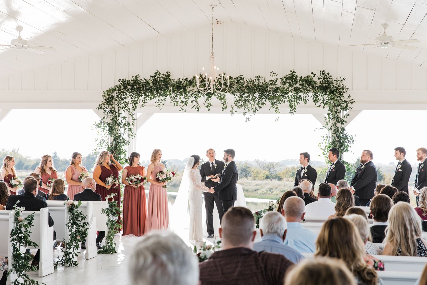 Backlit of the bride and groom exchanging vows in the sun glare at The Grand Ivory.