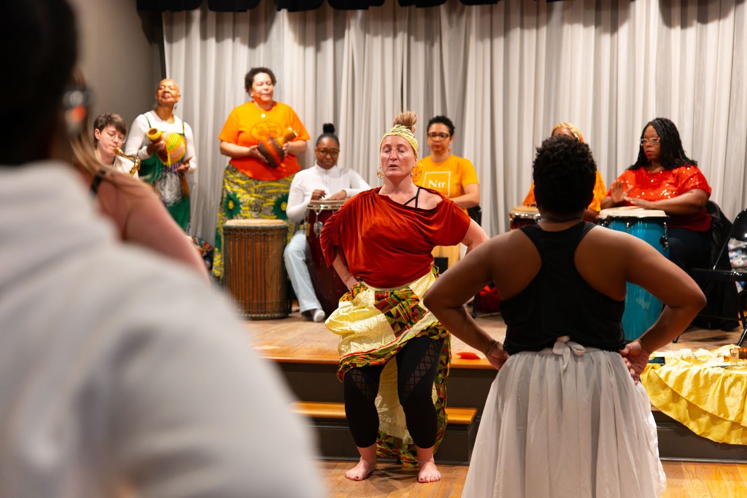 Dance rehearsal in a studio with performers practicing in casual attire.