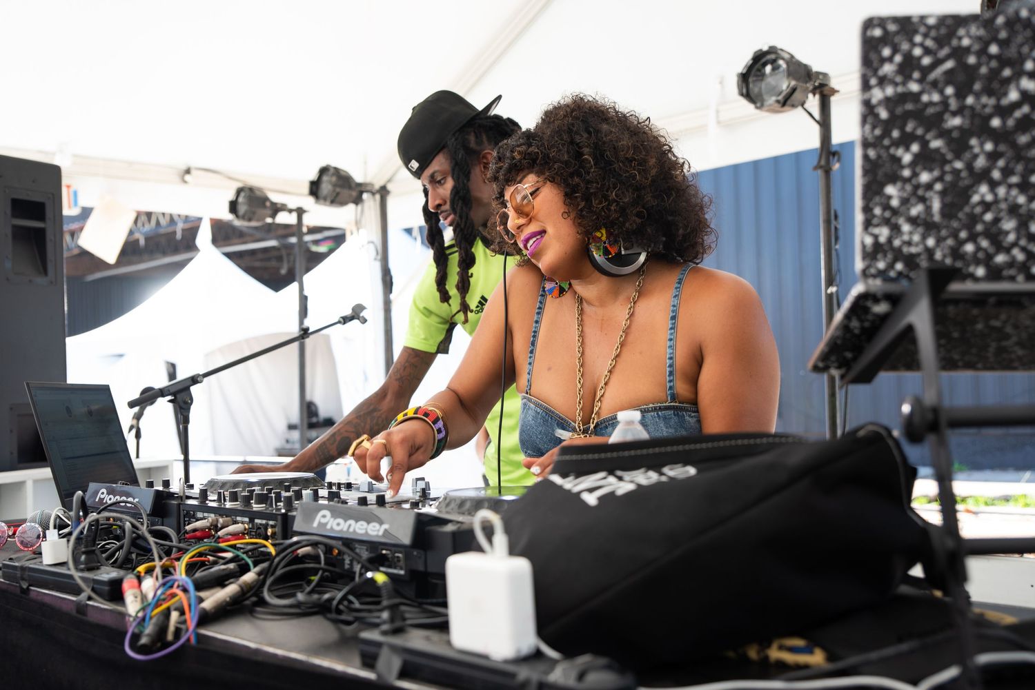 DJ equipment setup at an outdoor event with mixing boards and controllers.