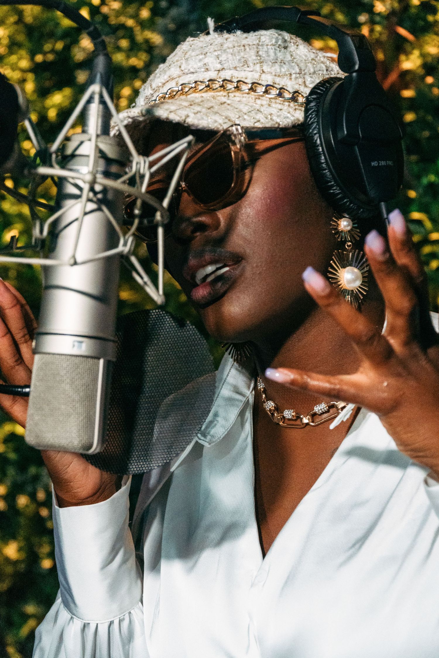Singer recording vocals in professional studio with condenser microphone.