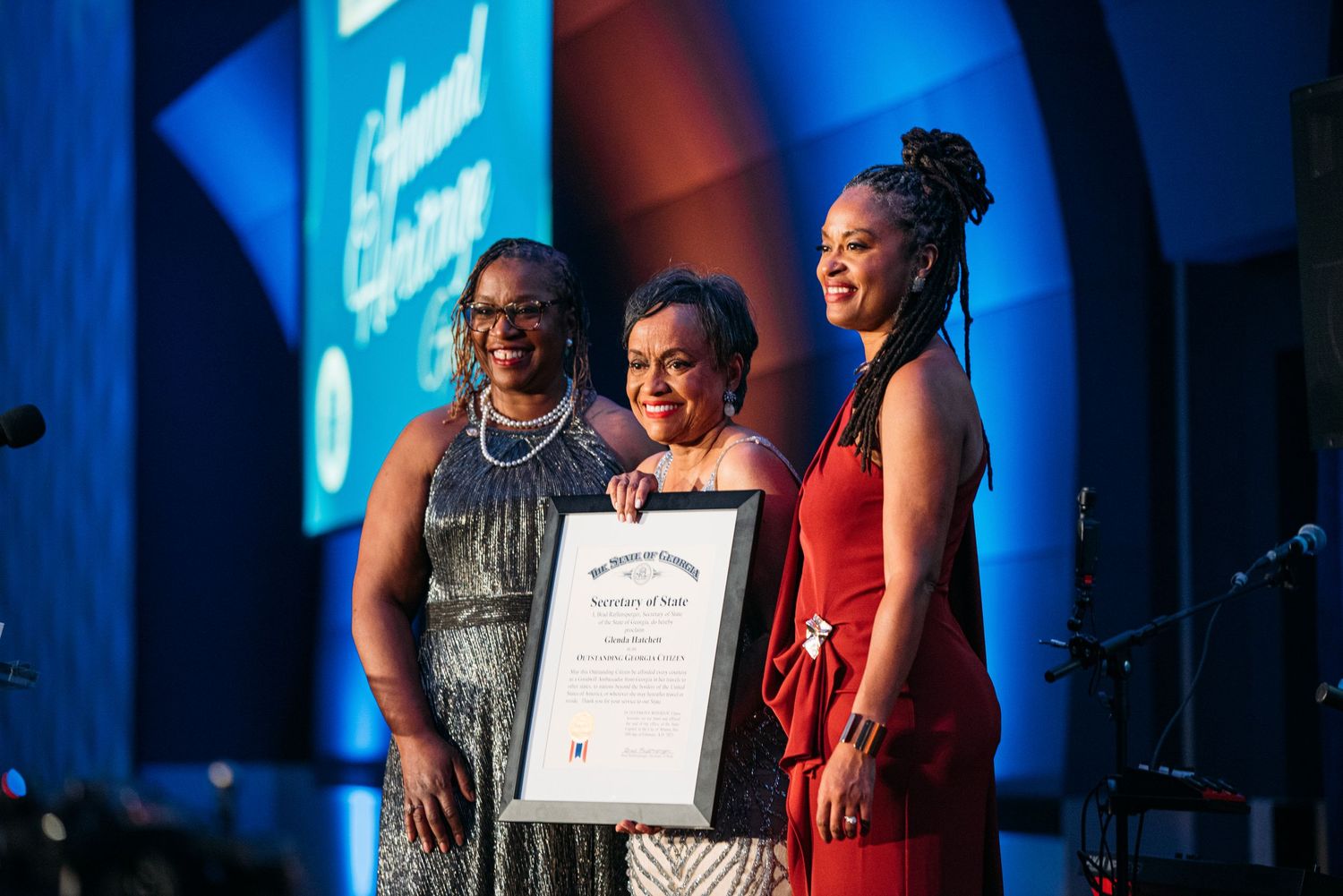 Award ceremony presentation on stage with blue lighting and projection effects.